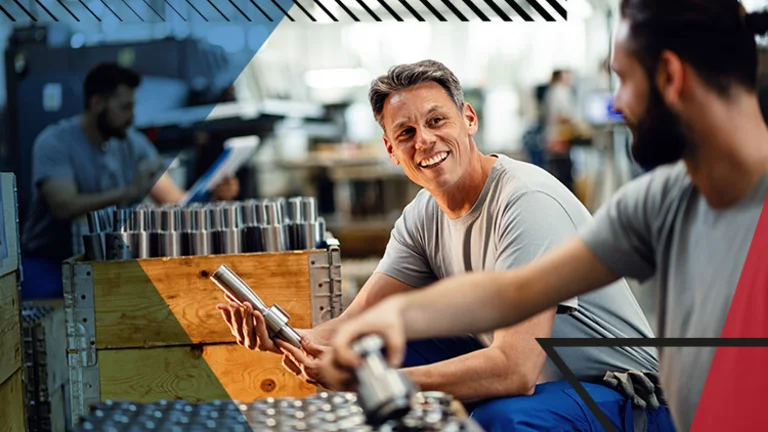 Man smiling and looking at his co-worker whilst working on steel products. Overlayed with Make UK branding