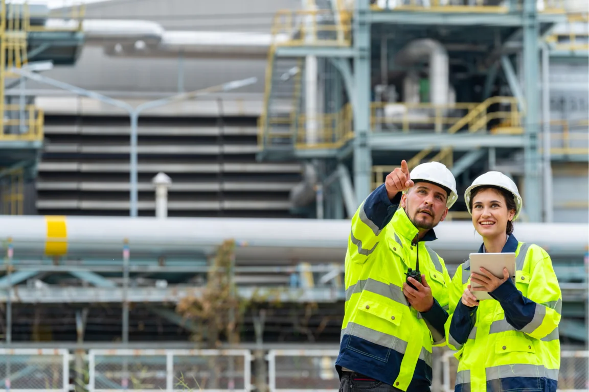 Two workers in hi viz jackets outside a facility