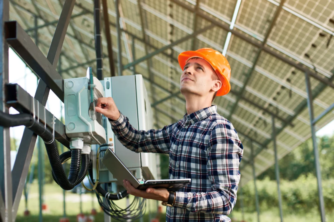 Man in hard hat looking at solar panels