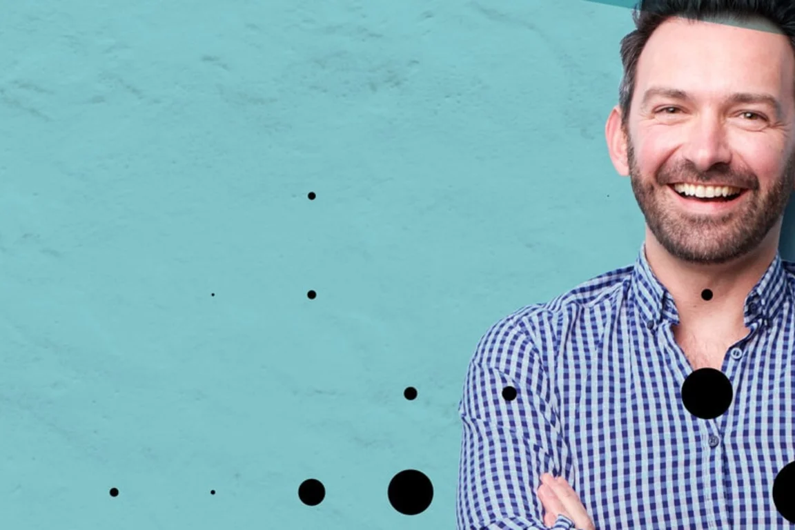 Man smiling in check shirt in front of blue background. Overlayed with Make UK branding